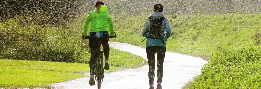 Laufen und Fahrradfahren im Regen