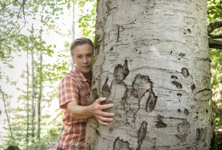 Hier sehen Sie die Bayern Botschafterin und Waldbademeisterin Elke Seidel. Sie umarmt eine Birken Baum.
