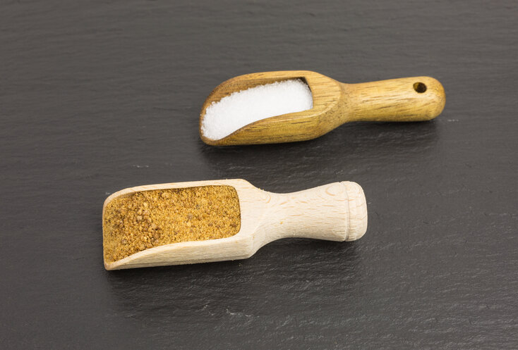 Hier sehen Sie zwei Küchenschaufeln aus Holz, in denen jeweil unterschiedliche Zucker alternativen drin sind. 