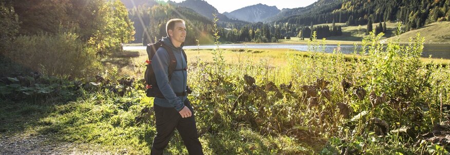 Hier sehen Sie Philipp Lahm, der auf einem Weg an einem Wald spazieren geht.