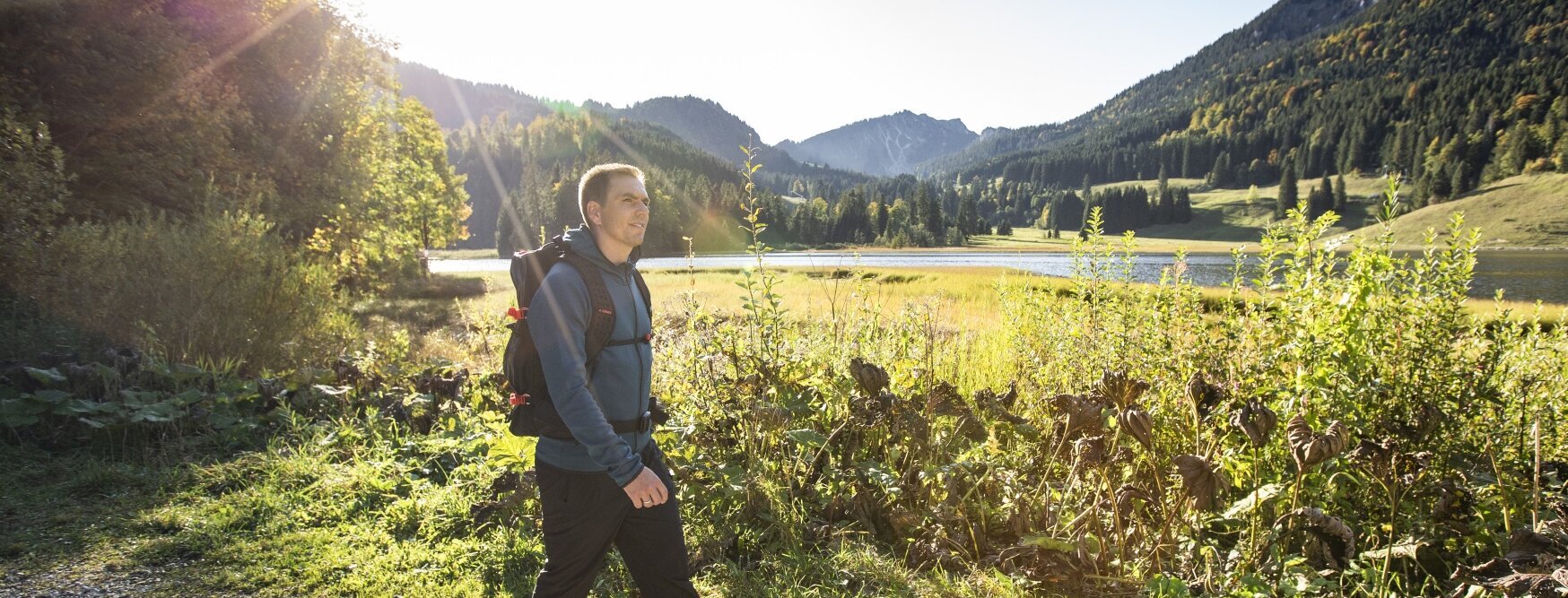 Hier sehen Sie Philipp Lahm, der auf einem Weg an einem Wald spazieren geht.