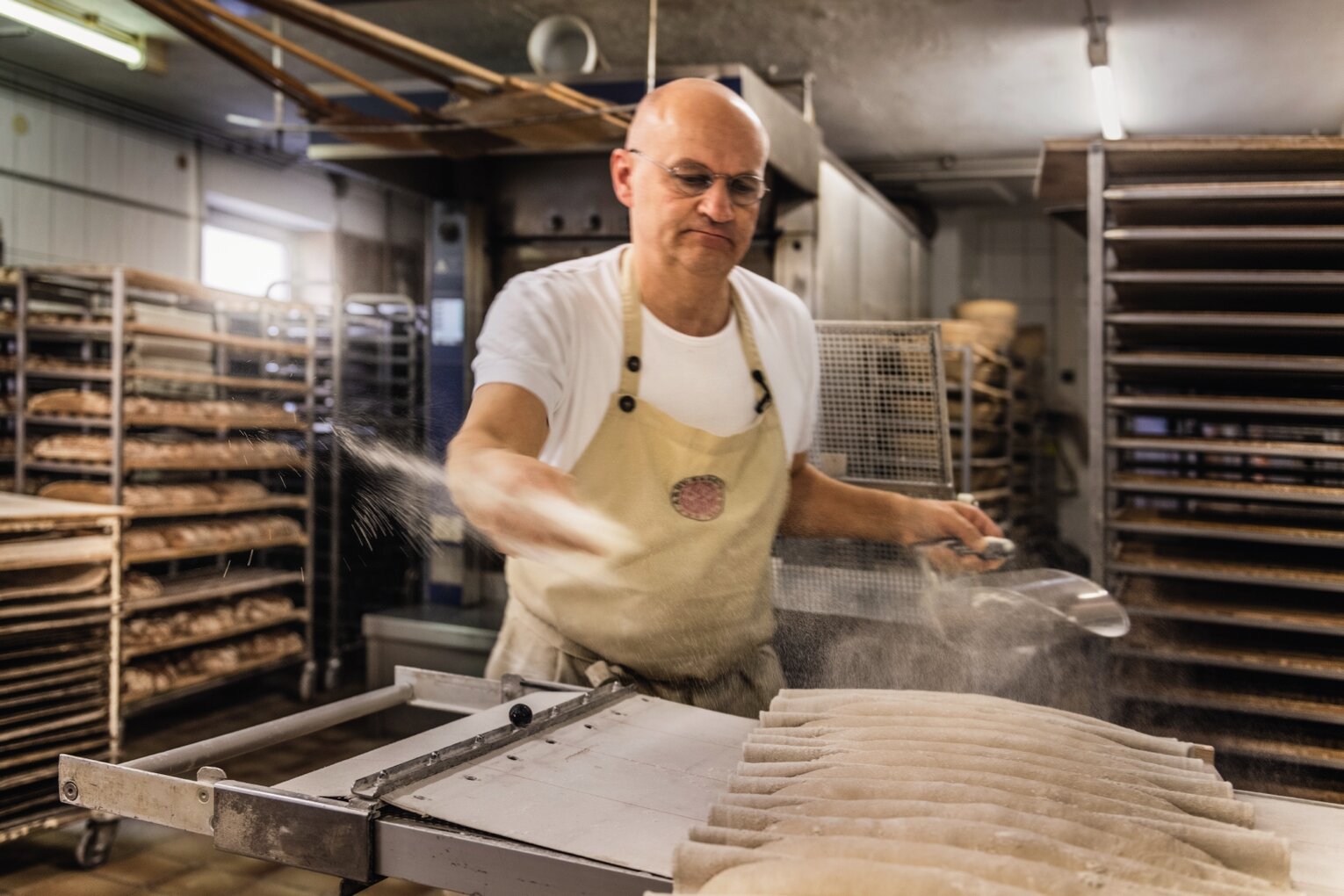 Hier sehen Sie den Bayern Botschafter Arnd Eberl. Er steht in seiner Backstube und bereitet frisches Brot zu. 