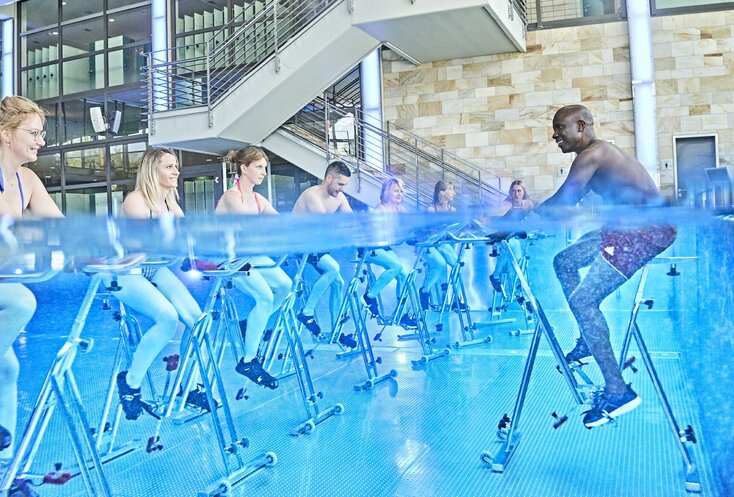 Hier sehen Sie Michel Frenzel-Assih und einige andere Menschen, wie sie unter Wasser Fahrrad fahren