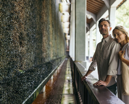 Ein Paar steht vor einer Mooswand und genießt das gute Klima