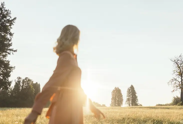 Frau geht im Sonnenlicht
