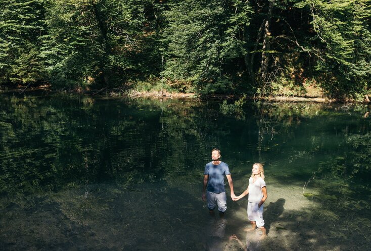 Paar steht in der Sonne und hält Händchen im Wasser