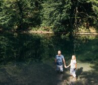 Paar steht in der Sonne und hält Händchen im Wasser