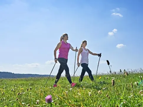 Zwei Frauen walken in der Sonne