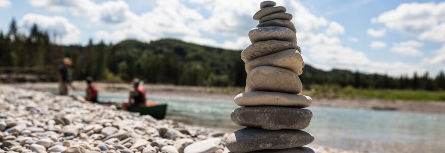 Hier sehen Sie eine Steinpyramide am Rande eines Flusses. 