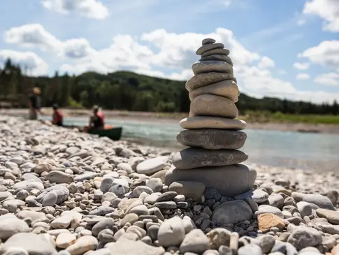 Hier sehen Sie eine Steinpyramide am Rande eines Flusses. 