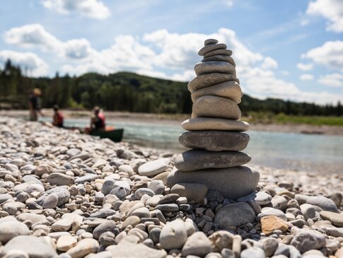 Hier sehen Sie eine Steinpyramide am Rande eines Flusses. 