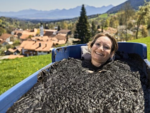 Hier sehen Sie eine Frau, die in de Natur ein Moorbad genießt. 